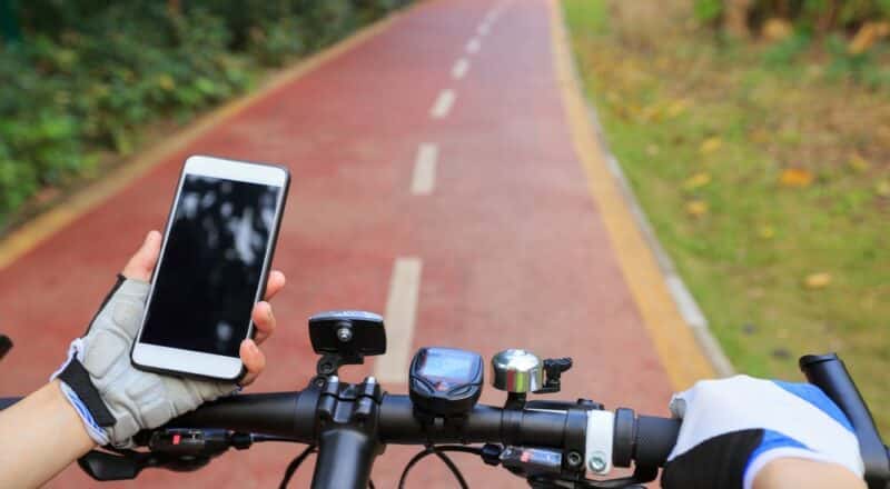 Cyclist,Hands,Use,Gps,Navigator,On,Smartphone,While,Biking